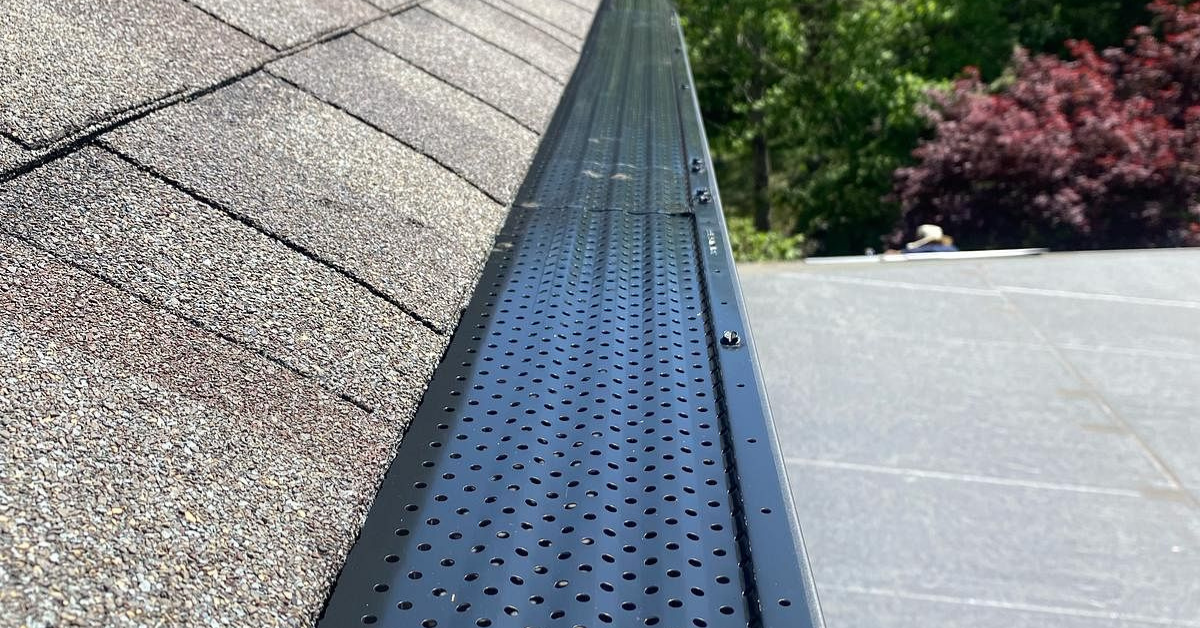 A perforated gutter guard system preventing debris buildup, improving drainage, and reducing water-related damage during summer storms.