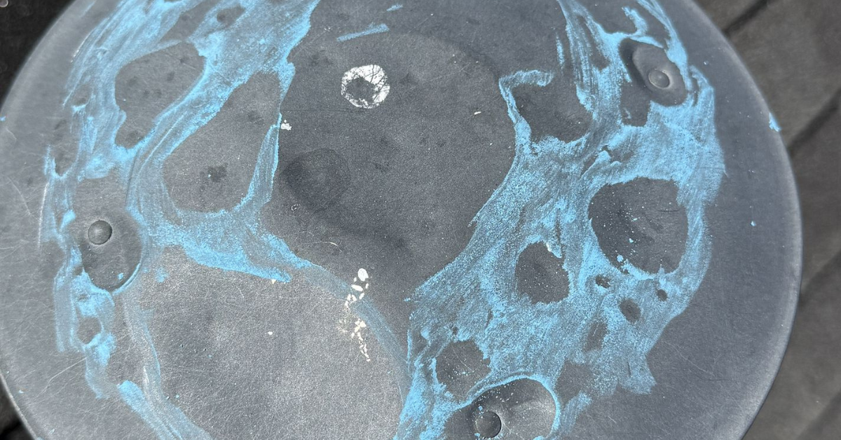 Dented metal vent cap showing multiple hail impact marks—documented for roof insurance claim