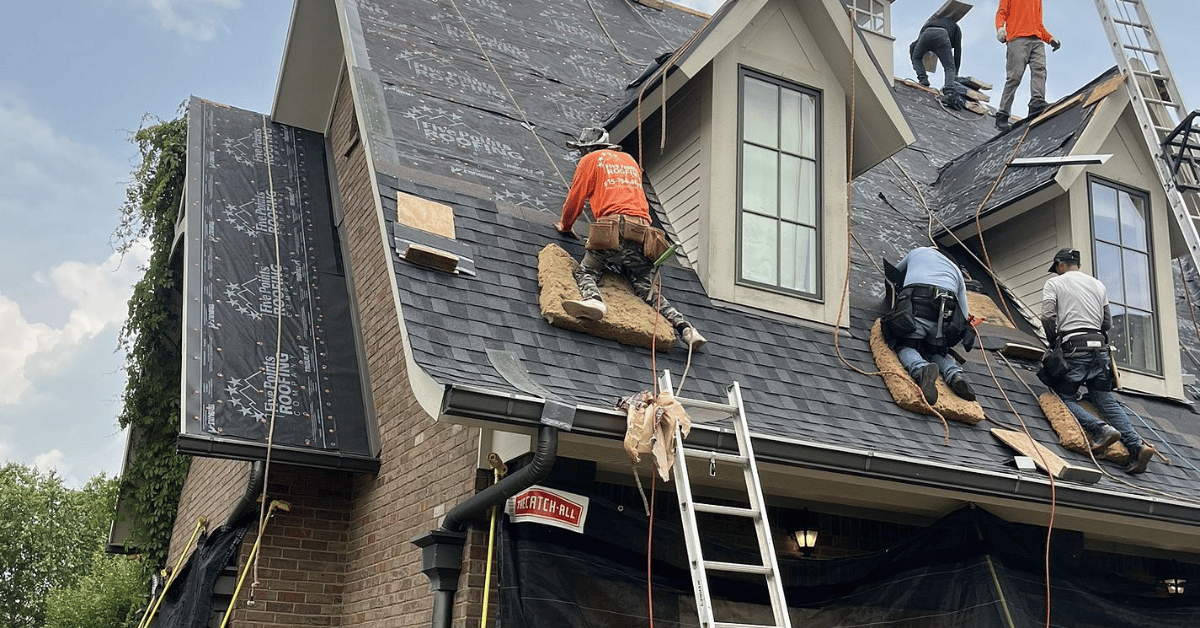 Roofing contractors from Five Points Roofing replacing shingles during a covered roof claim project.