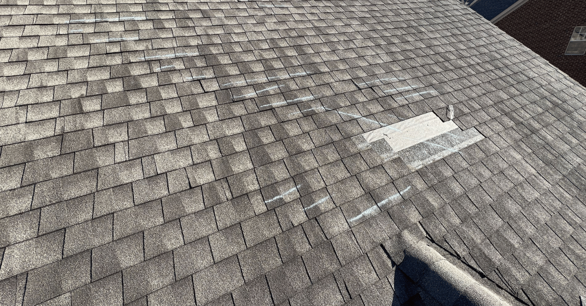 Chalk Markings Showing Widespread Shingle Damage Roof section showing multiple chalk-marked shingles indicating wind lift and shingle displacement.