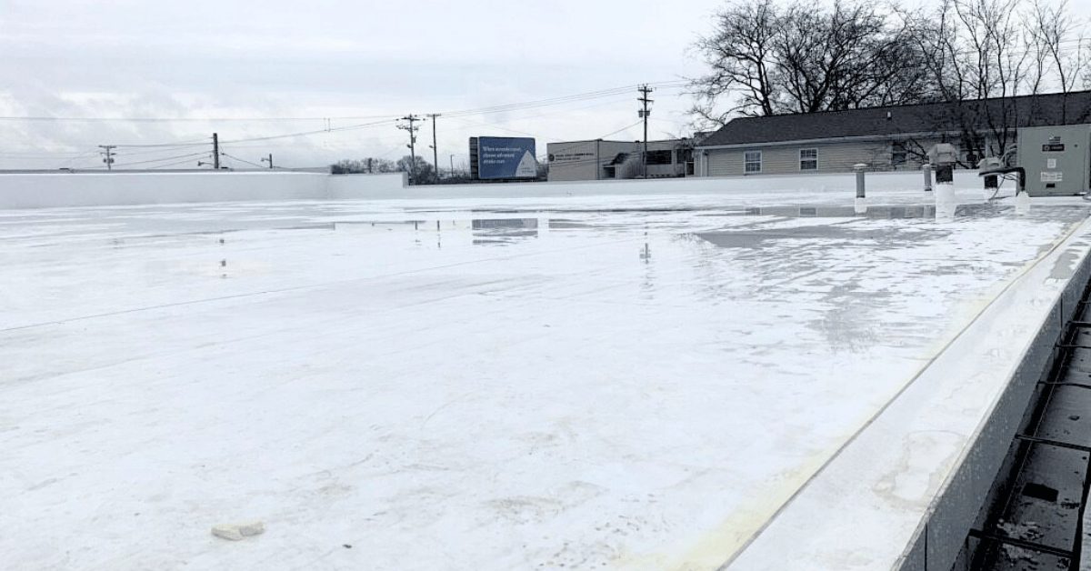 Finished flat roof with reflective white TPO membrane installed over the concrete deck for improved waterproofing and energy efficiency.