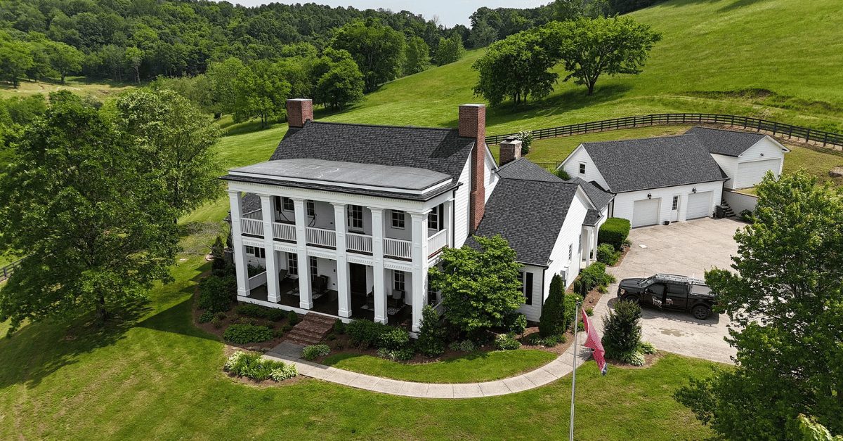 Finished Roof Replacement in College Grove, TN – Front View Aerial view of a historic white home in College Grove with a new black CertainTeed Landmark Pro roof and manicured landscaping.