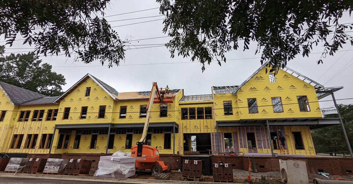Roofing crew lifts materials to upper story during early installation phase of Franklin commercial building.