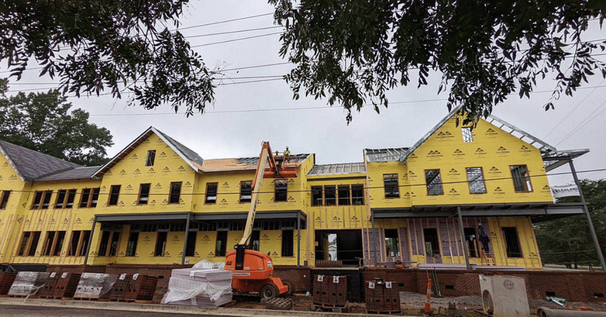 Roof Decking and Underlayment Installation Begins Roofing crew lifts materials to upper story during early installation phase of Franklin commercial building.