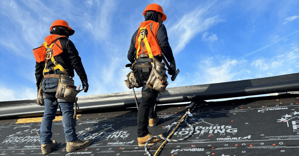 Roofer Safety Harnessed on Steep Slope Two team members safely secured while preparing ridge edge on the Hillsboro Church roof.