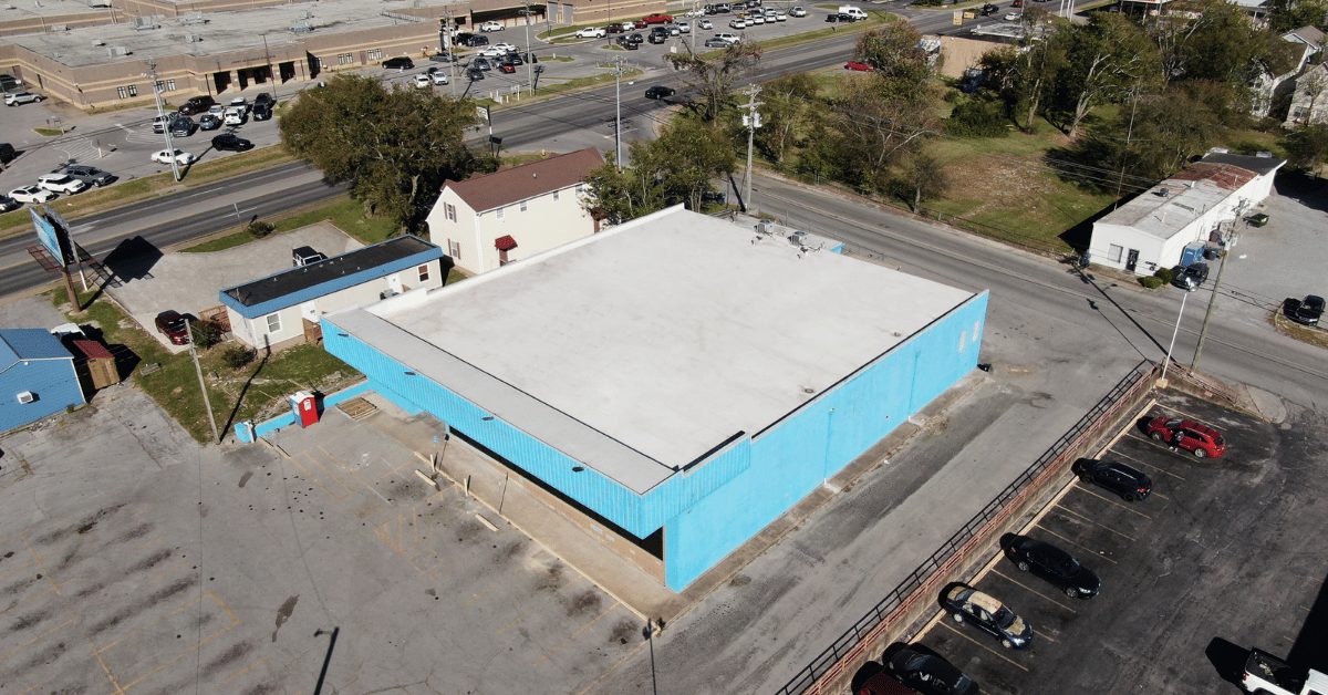 Side Angle of Flat Roof Completion Side aerial perspective of the Lebanon Thrift Building, highlighting the smooth, waterproof TPO roofing system installed by Five Points Roofing.