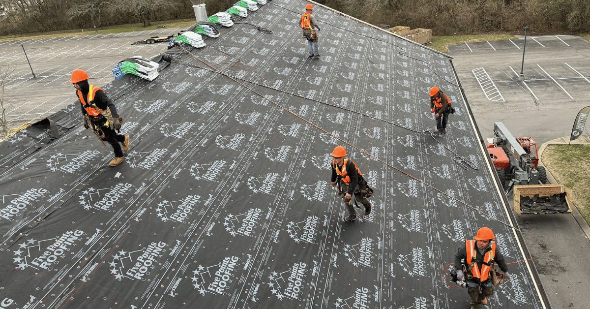 Roofing crew installing Tri-Built synthetic underlayment during roof replacement at Hillsboro Church.