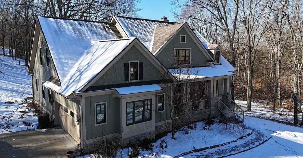 A home in Spring Hill, Tennessee showing snow-covered roofing—a key reason why weather delays roof installation during winter months