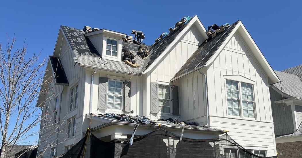 Five Points Roofing crew working on a complex roof installation with steep slopes and dormers during clear weather in Franklin, Tennessee.