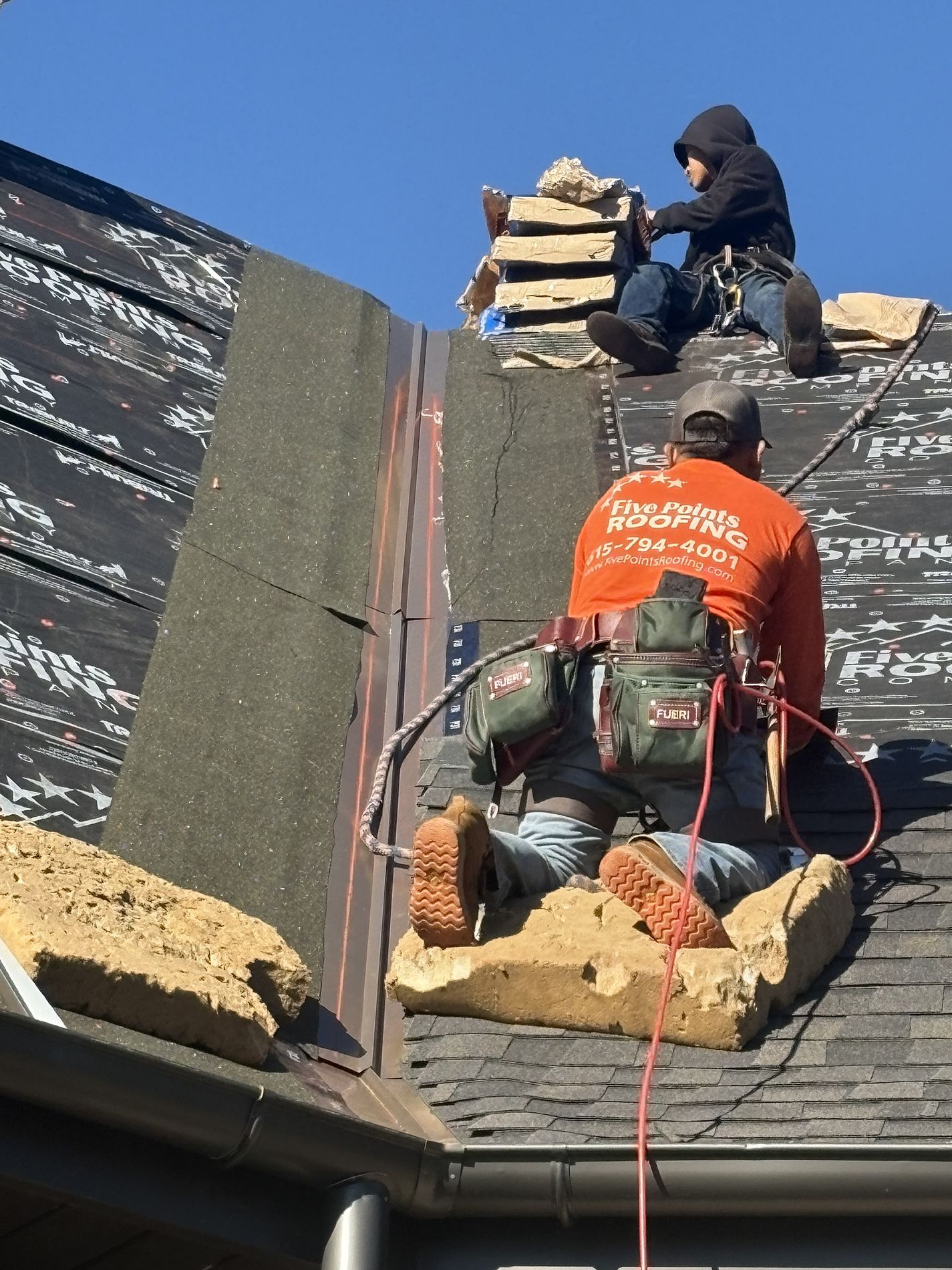 five points roofing installer on roof nailing down shingles