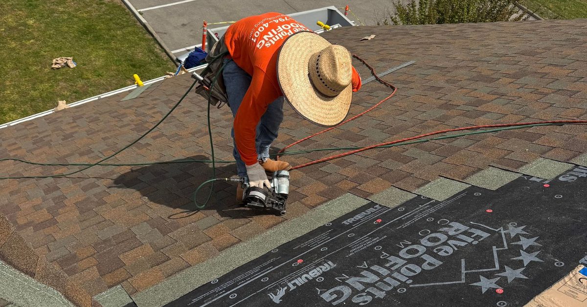 Five Points Roofing Crew Installing Shingles — Franklin, TN Five Points Roofing installer using a nail gun to lay asphalt shingles over branded TRI-BUILT underlayment on a residential roof