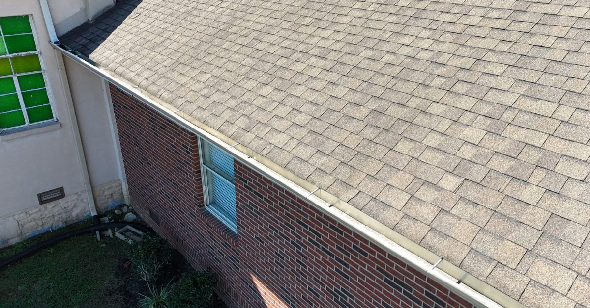 Wore out shingles at West Harpeth Primitive Church Aerial close-up of old gray asphalt shingles and gutters along the eave of a brick building in Middle Tennessee