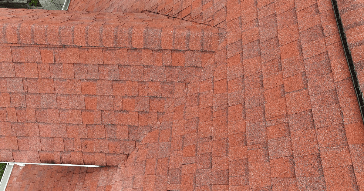 Close-up of red architectural asphalt shingles along a hip and valley seam on a Middle Tennessee roof